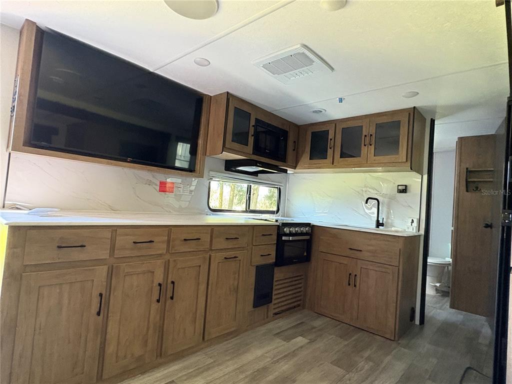 1575 Northeast 100th Street Anthony, FL 32617 - Photo 24 of 29 a kitchen with stainless steel appliances a stove microwave and sink