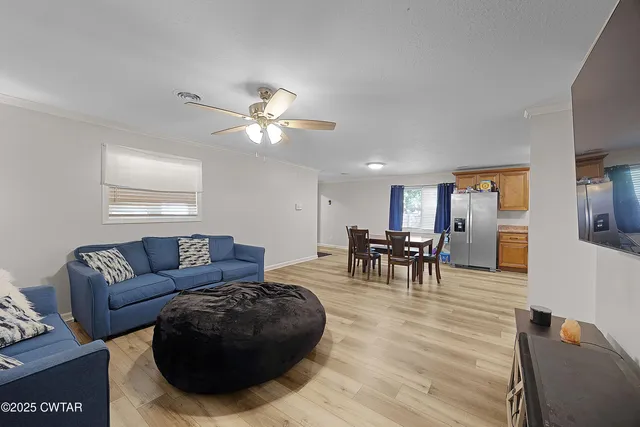 a living room with furniture and a dining table with kitchen view