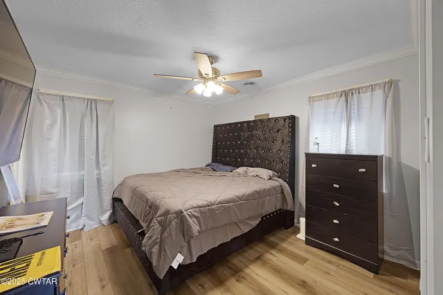 a bedroom with a bed and a ceiling fan