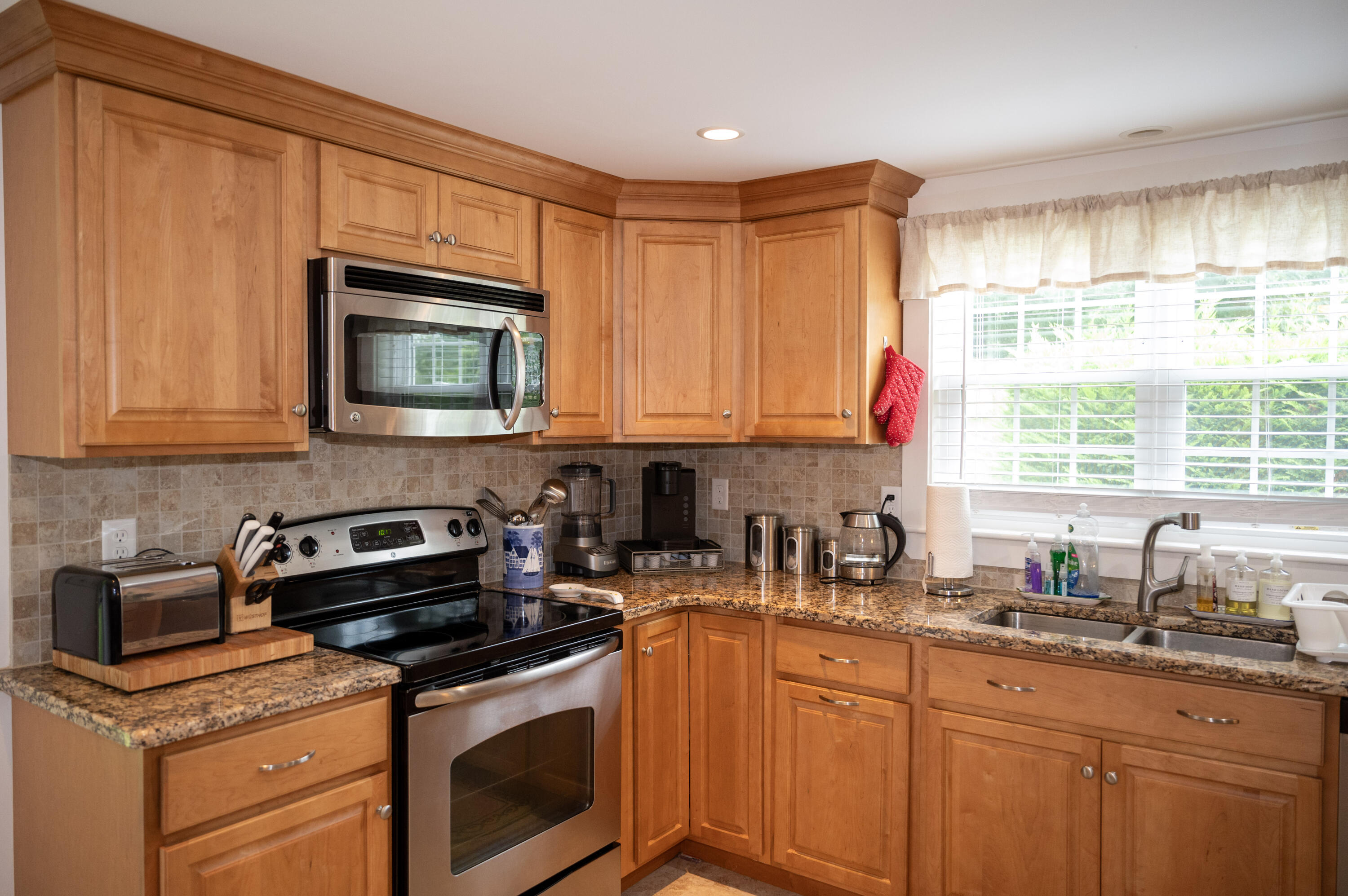 46 Bournedale Road Buzzards Bay, MA 02532 - Photo 18 of 46 a kitchen with stainless steel appliances granite countertop a sink a stove a microwave cabinets and a window
