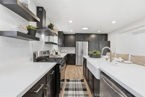 a kitchen with stainless steel appliances a sink stove and refrigerator