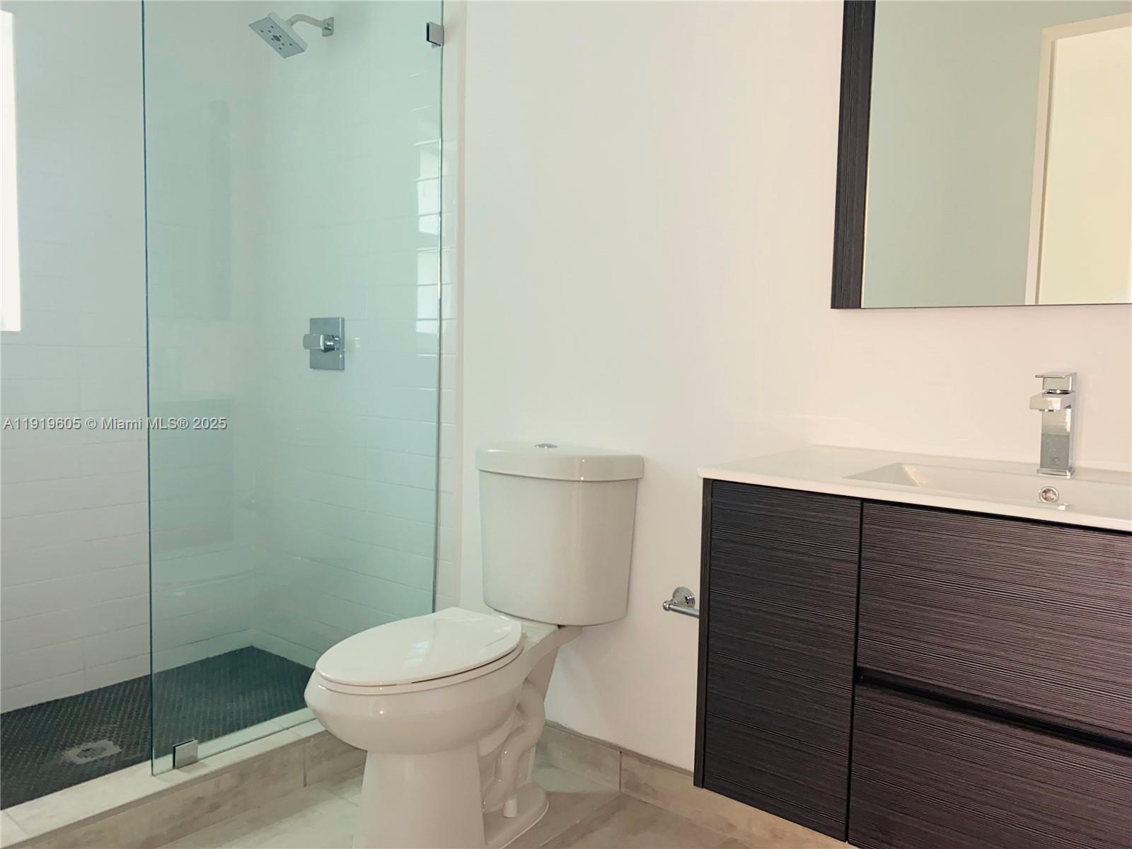 1201 Pennsylvania Avenue, Unit 206 Miami Beach, FL 33139 - Photo 3 of 9 a bathroom with a toilet a sink and shower