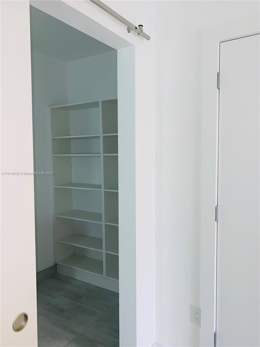1201 Pennsylvania Avenue, Unit 206 Miami Beach, FL 33139 - Photo 6 of 9 a view of walk in closet with empty racks