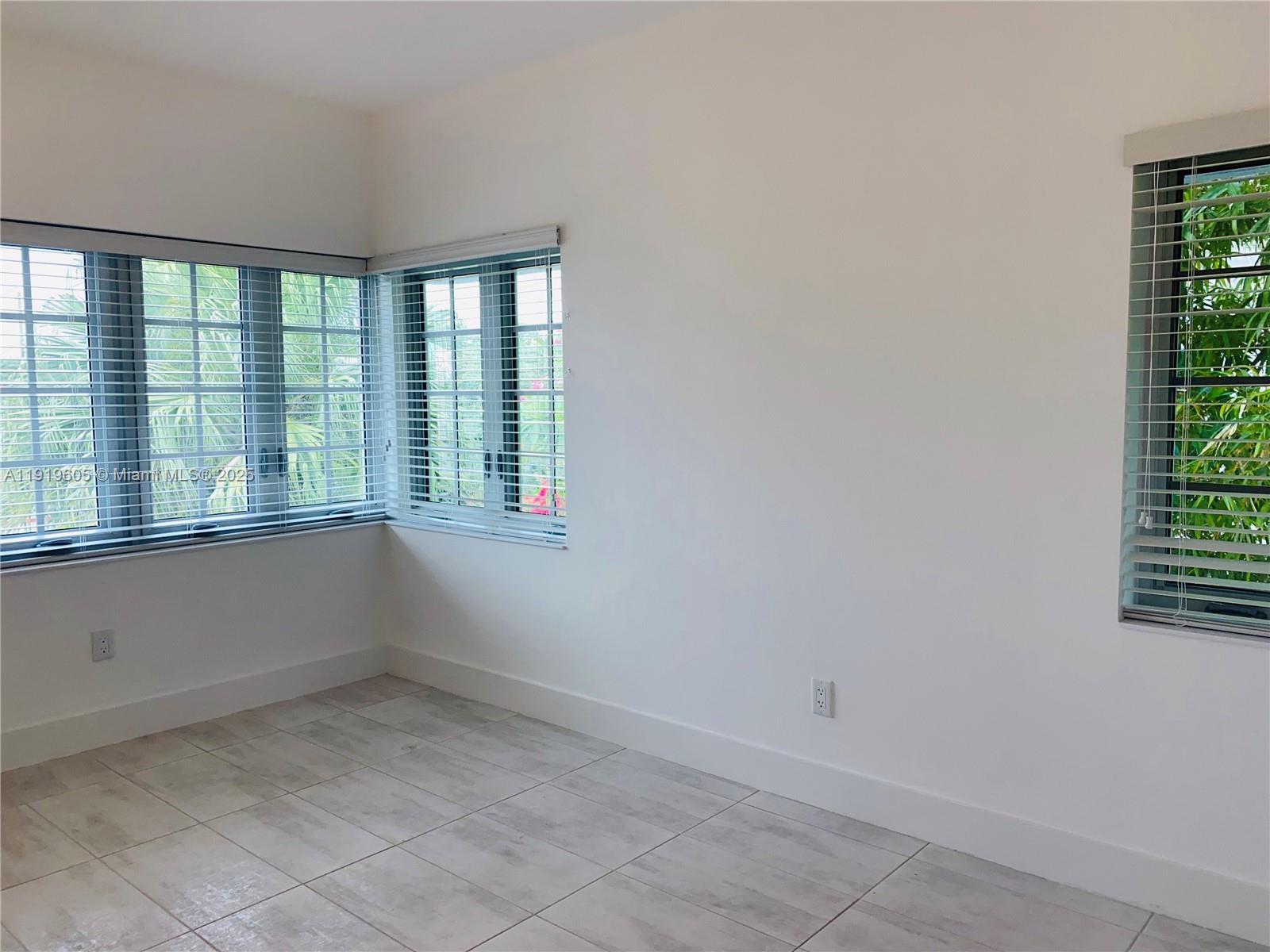 1201 Pennsylvania Avenue, Unit 206 Miami Beach, FL 33139 - Photo 7 of 9 an empty room with windows
