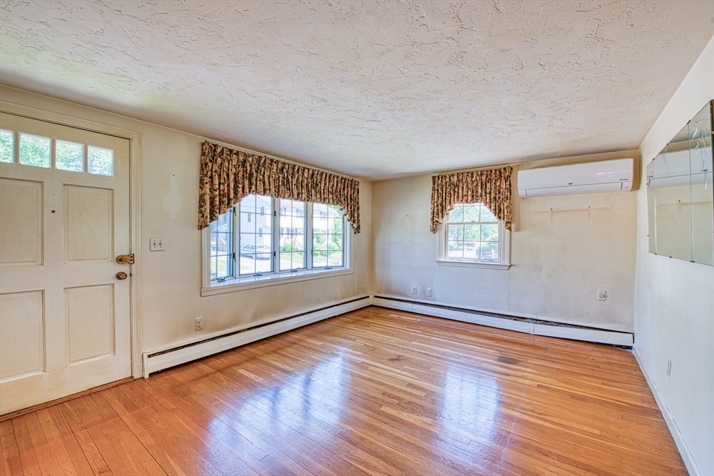 31 Rindone Street Holbrook, MA 02343 - Photo 4 of 23 an empty room with wooden floor and windows