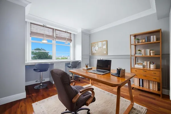 a view of a workspace with furniture and a window
