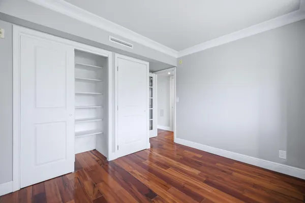 a view of empty room with wooden floor