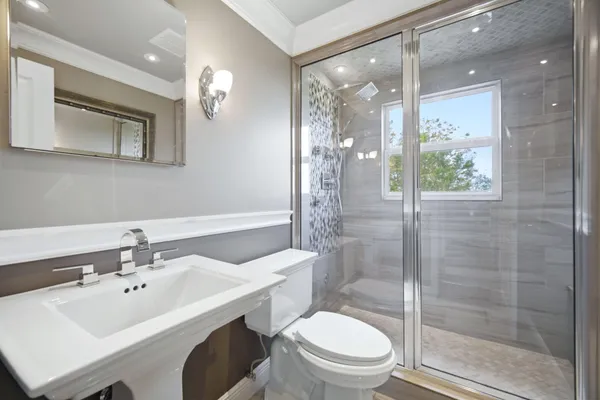 a bathroom with a sink a toilet and shower