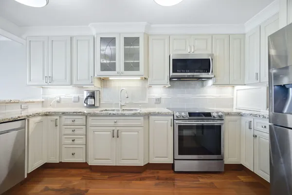 a kitchen with stainless steel appliances granite countertop a stove and a sink