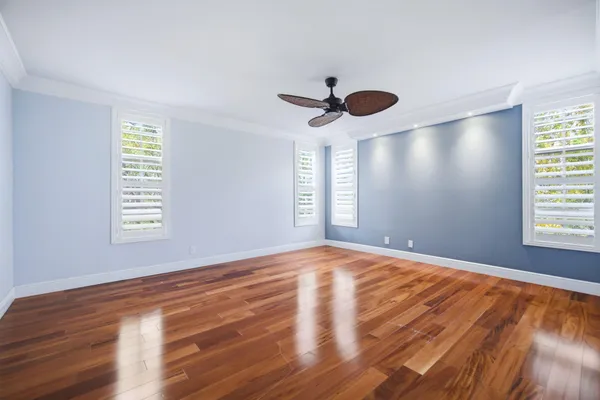a view of an empty room with window and wooden floor