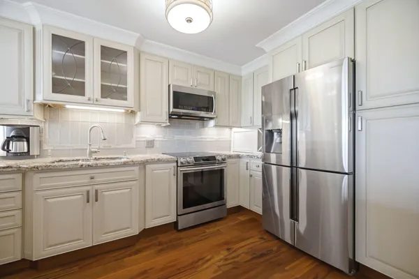 a kitchen with stainless steel appliances a refrigerator microwave and sink