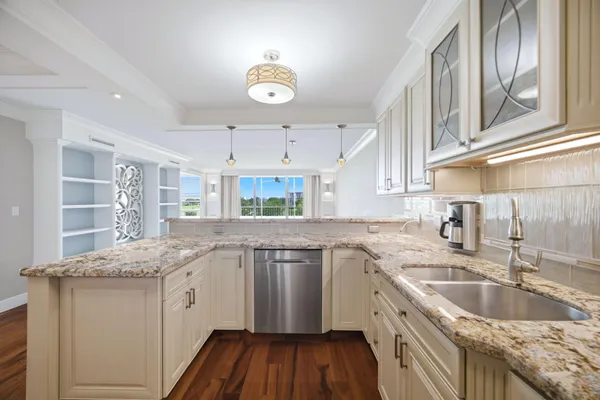 a kitchen with granite countertop a sink a counter space appliances and cabinets