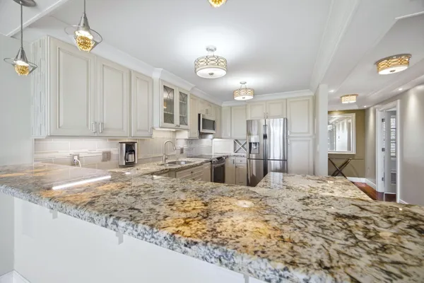 a large kitchen with kitchen island granite countertop a sink and cabinets