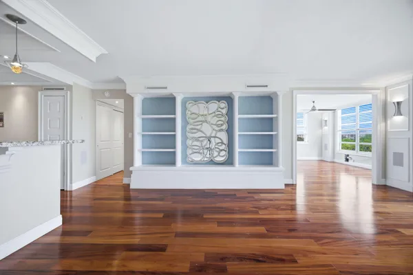 a view of an empty room with wooden floor and entryway