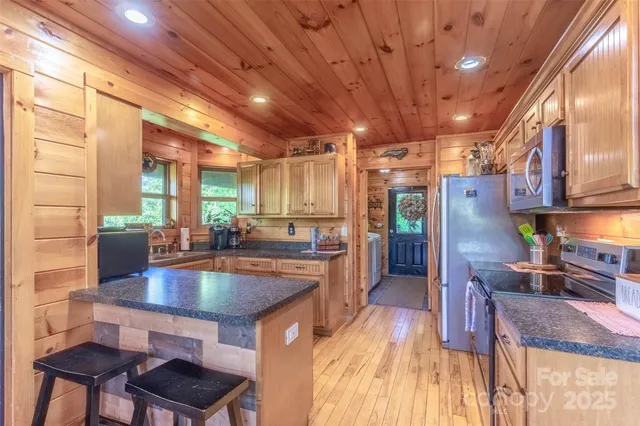 a kitchen with stainless steel appliances granite countertop a sink a stove and a refrigerator