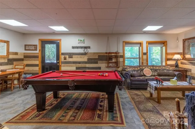 a living room with a piano table and windows