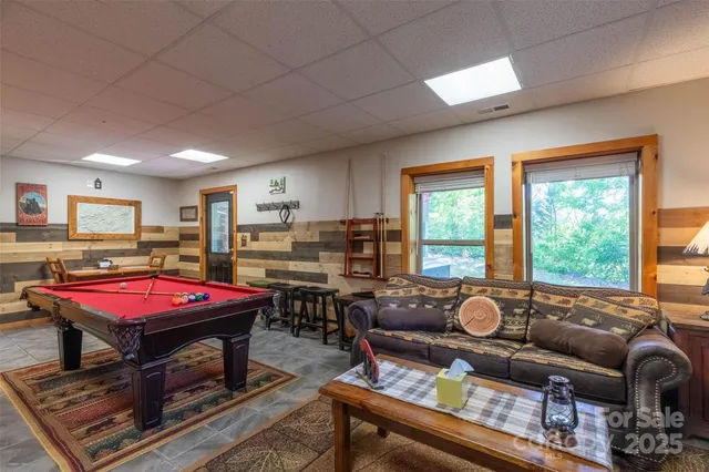a living room with furniture a pool table and a fireplace