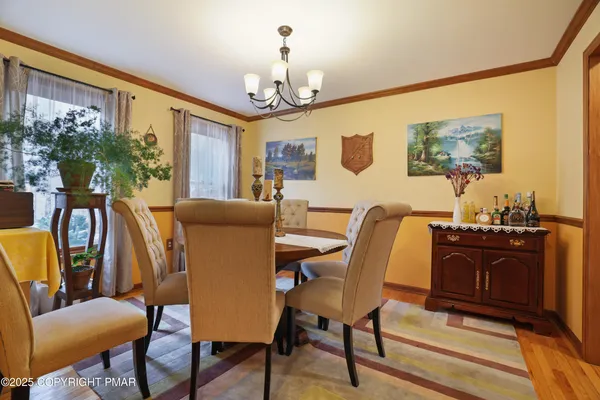 a view of a dining room with furniture a chandelier and wooden floor
