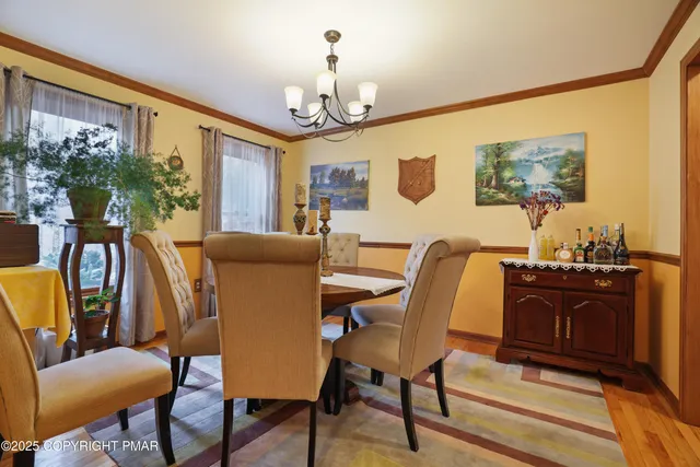 a view of a dining room with furniture a chandelier and wooden floor