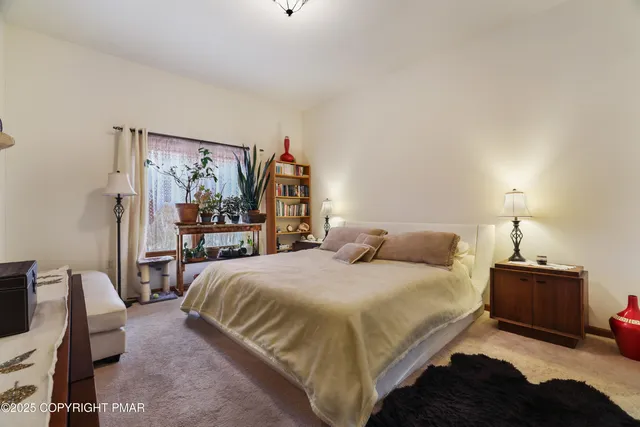 a bedroom with a bed a table and chair