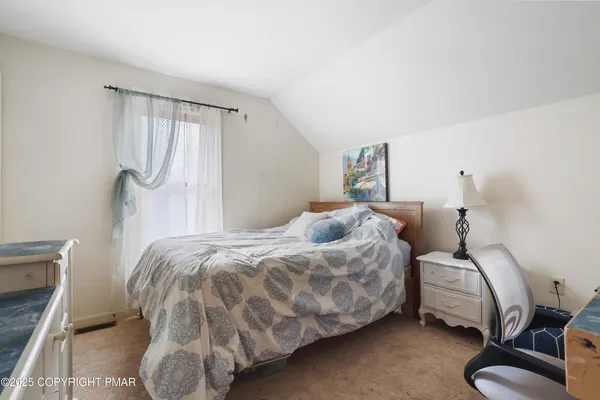 a bedroom with a bed and a chair