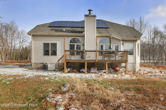 a front view of a house with a yard covered with snow