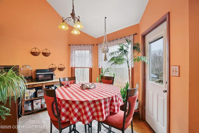 a dining room with furniture and a potted plant