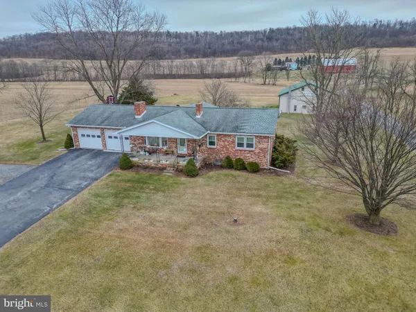a view of a house with a yard and a large tree