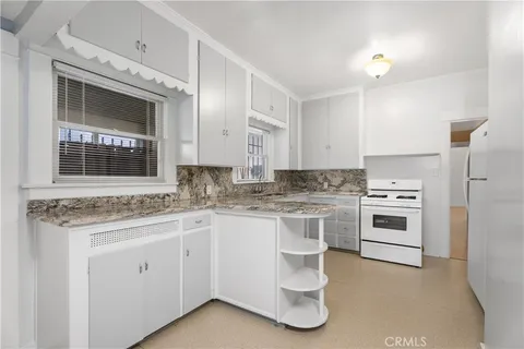a kitchen with a stove sink and cabinets