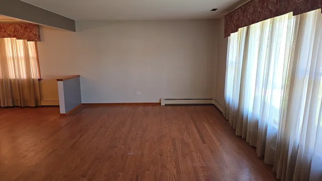 a view of a room with wooden floor and large window