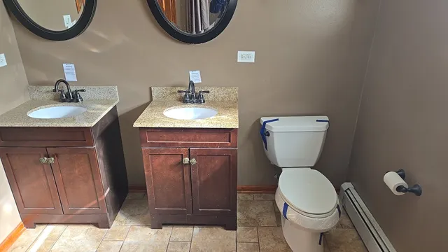 a bathroom with a toilet a sink a mirror and vanity