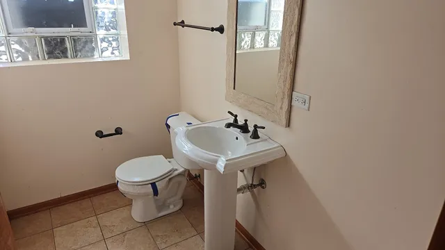 a bathroom with a sink toilet and mirror
