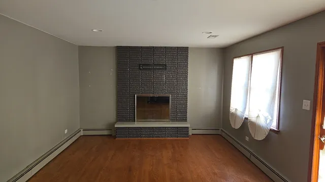 a view of an empty room with a fireplace and a window