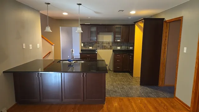 a view of a kitchen with refrigerator and wooden floor