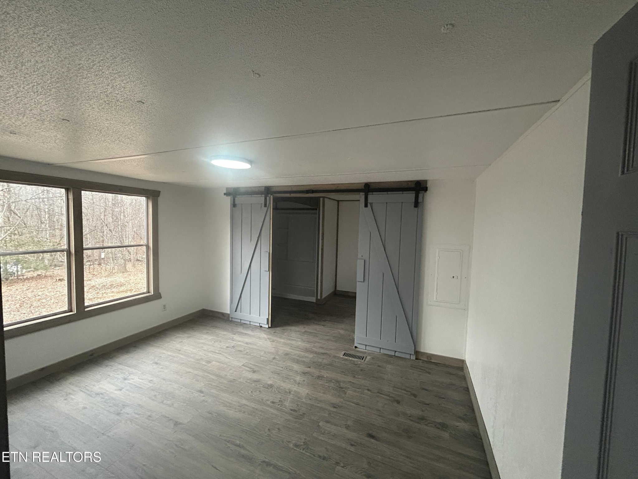 994 Pioneer Road Grimsley, TN 38565 - Photo 19 of 20 an empty room with a fireplace and windows