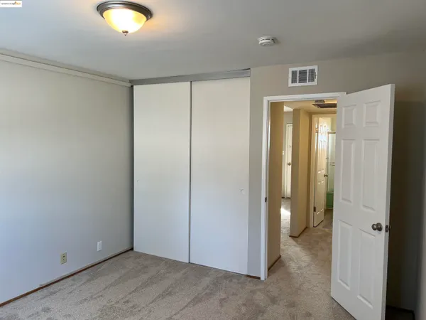 an empty room with closet and wooden door
