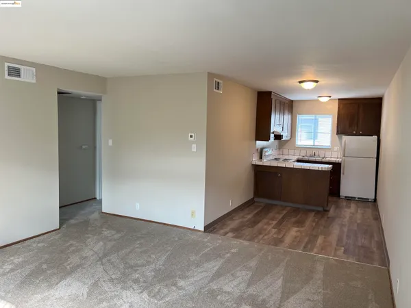 a kitchen with a sink a refrigerator a window and cabinets