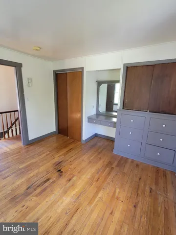 an empty room with wooden floor and cabinet
