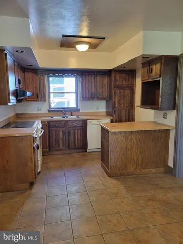 a large kitchen with cabinets and a stove top oven