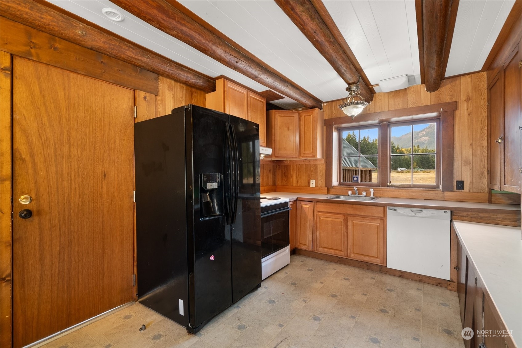 111 Huntington Road Packwood, WA 98361 - Photo 20 of 40 a kitchen with granite countertop a refrigerator and white cabinets
