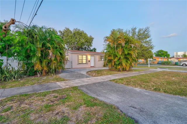 a view of a house with backyard and a tree