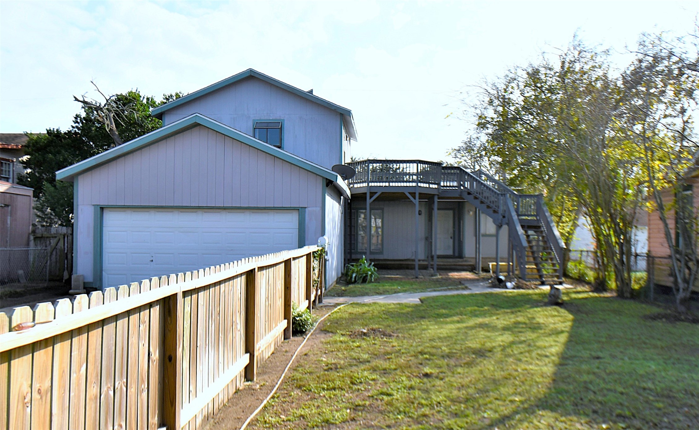 a view of a house with a yard and fence