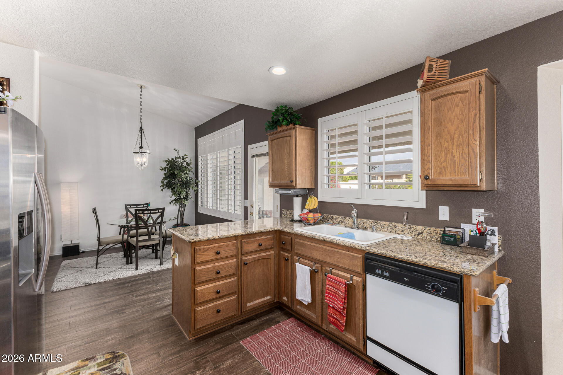 15764 Piccadilly Road Goodyear, AZ 85395 - Photo 11 of 31 a kitchen that has a lot of cabinets in it and wooden floors