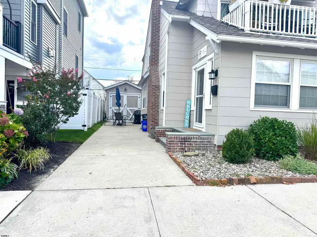 a view of a brick house with many windows plants and palm trees