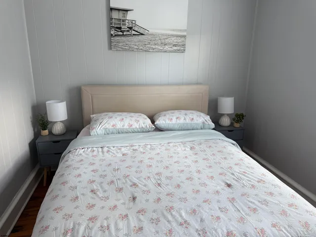 a bedroom with a bed and a wooden floor