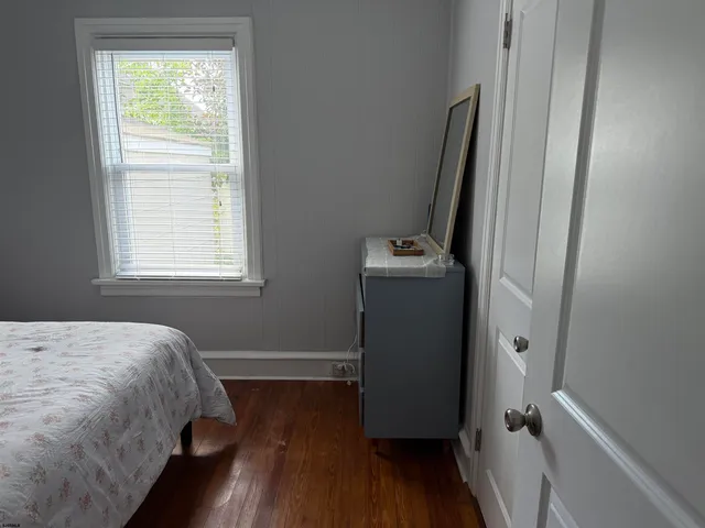 a bedroom with a bed and a wooden floor