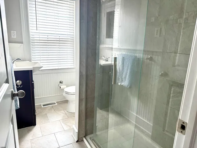 a bathroom with a granite countertop shower and a toilet