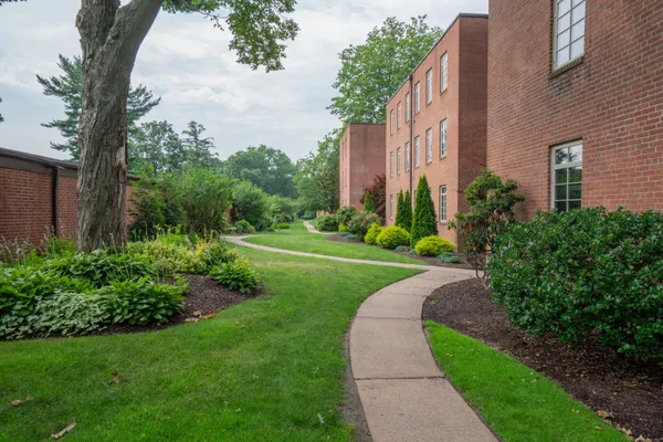 a view of a tall brick building next to a yard