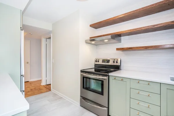 a kitchen with stainless steel appliances granite countertop white cabinets and a stove