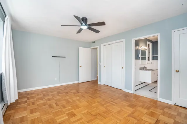 a view of a big room with wooden floor and windows